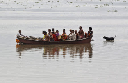 A man pulls a boat carrying devotees on the flooded banks of the river Ganges after heavy rains in Allahabad, India, July 5, 2016. REUTERS/Jitendra Prakash