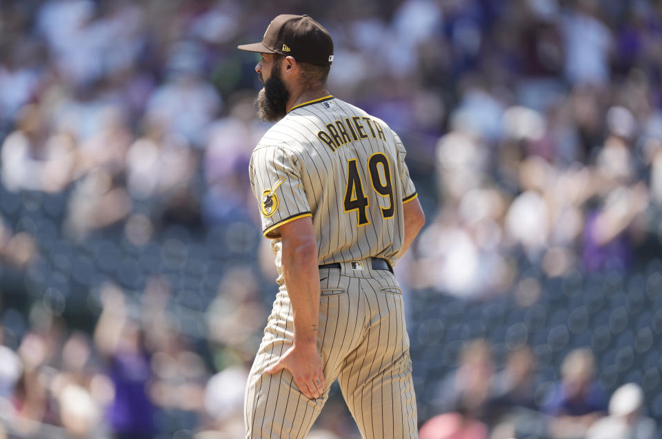 San Diego Padres starting pitcher Jake Arrieta holds the back of his left leg after giving up a solo home run to Colorado Rockies' Dom Nunez in the fourth inning of a baseball game Wednesday, Aug. 18, 2021, in Denver. Arrieta, who was making his first start for the Padres, was forced to leave the game. (AP Photo/David Zalubowski)