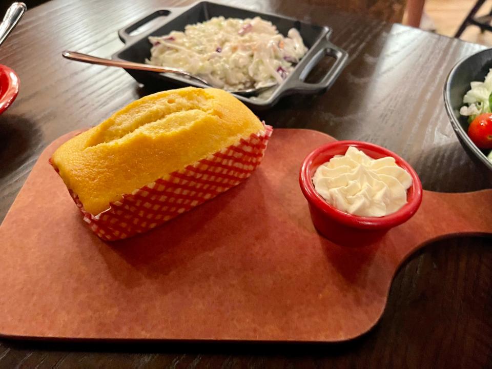Hoop-De-Doo Revue at Disney - a corn bread loaf on a cutting board next to a bowl of whipped butter