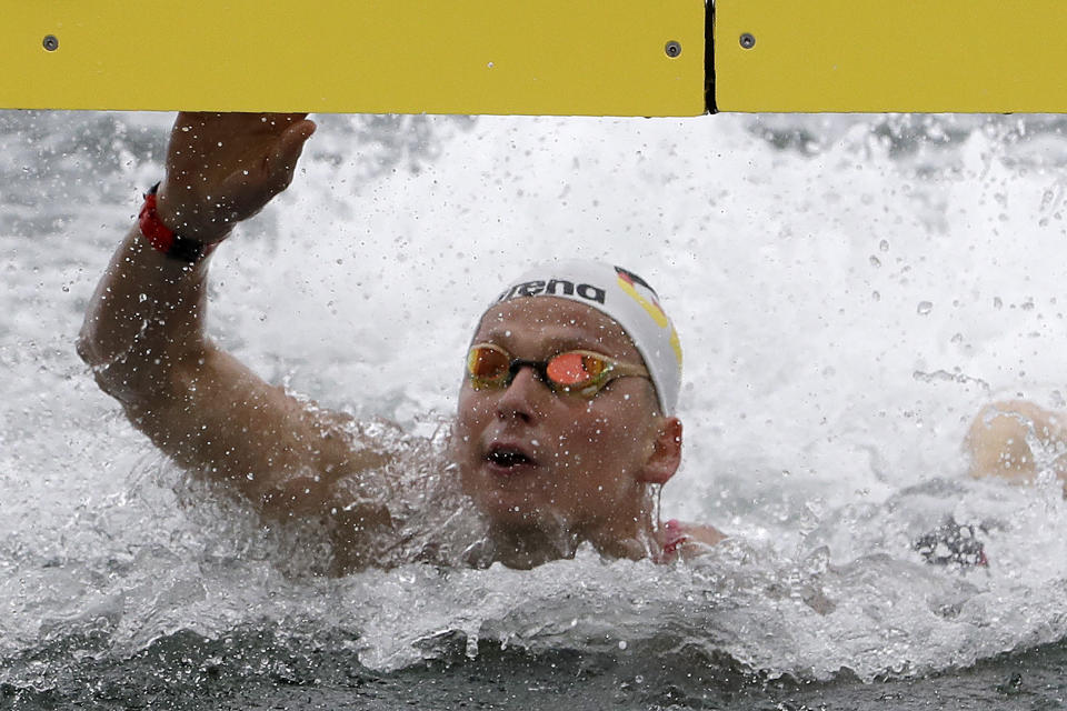 Rob Muffels of Germany touches the timing board to win the 5km mixed relay open water swim at the World Swimming Championships in Yeosu, South Korea, Thursday, July 18, 2019. (AP Photo/Mark Schiefelbein)