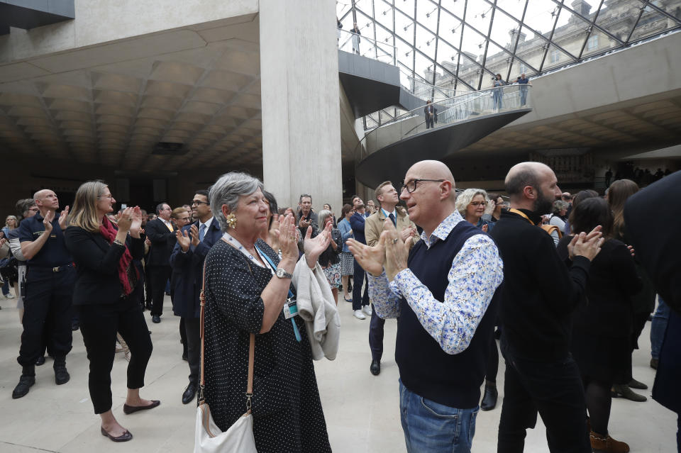 Le Louvre museum employees applaud to pay tribute to the architect of its giant glass pyramid, I.M. Pei, Friday, May 17, 2019 in Paris. Pei died earlier this week at the age of 102. (AP Photo/Michel Euler)