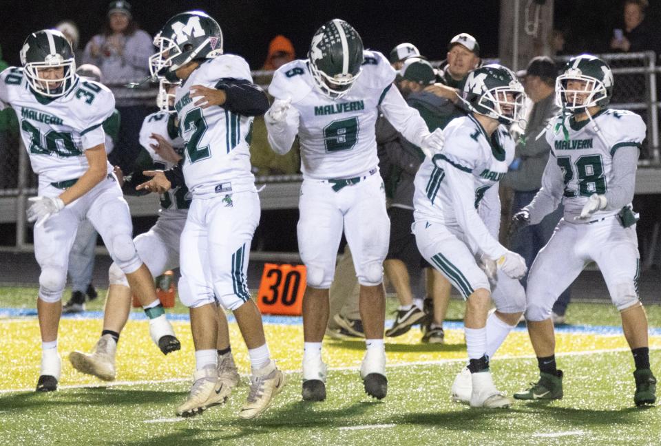 Malvern’s Kaden Grinder (left), Manny Walker, Bryson White, Dylan Phillips, and Ibai Aguirre celebrate defeating East Canton and winning the Inter-Valley Conference North Division championship Friday, Oct. 22, 2021.