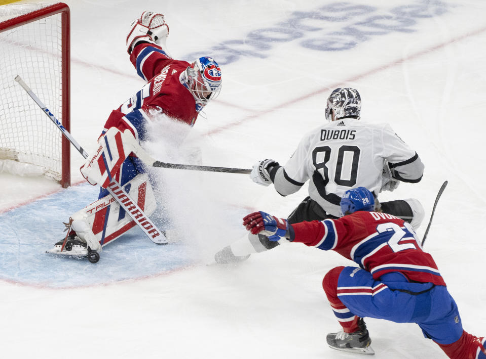 Montreal Canadiens goaltender Sam Montembeault (35) stops a shot by Los Angeles Kings' Pierre-Luc Dubois (80) as Canadiens' Christian Dvorak (28) defends during the second period of an NHL hockey game Thursday, Dec. 7, 2023, in Montreal. (Christinne Muschi/The Canadian Press via AP)