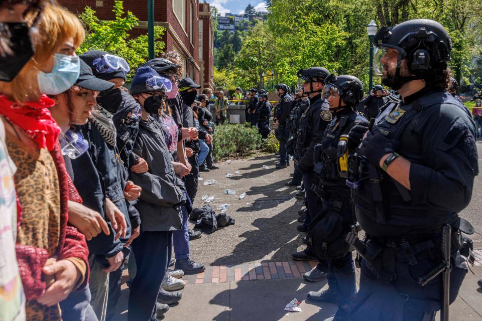 Pro-Palestinian students and activists face police officers after protesters were evicted from the library on campus earlier in the day at Portland State University in Portland, Oregon on May 2, 2024 (AFP via Getty Images)