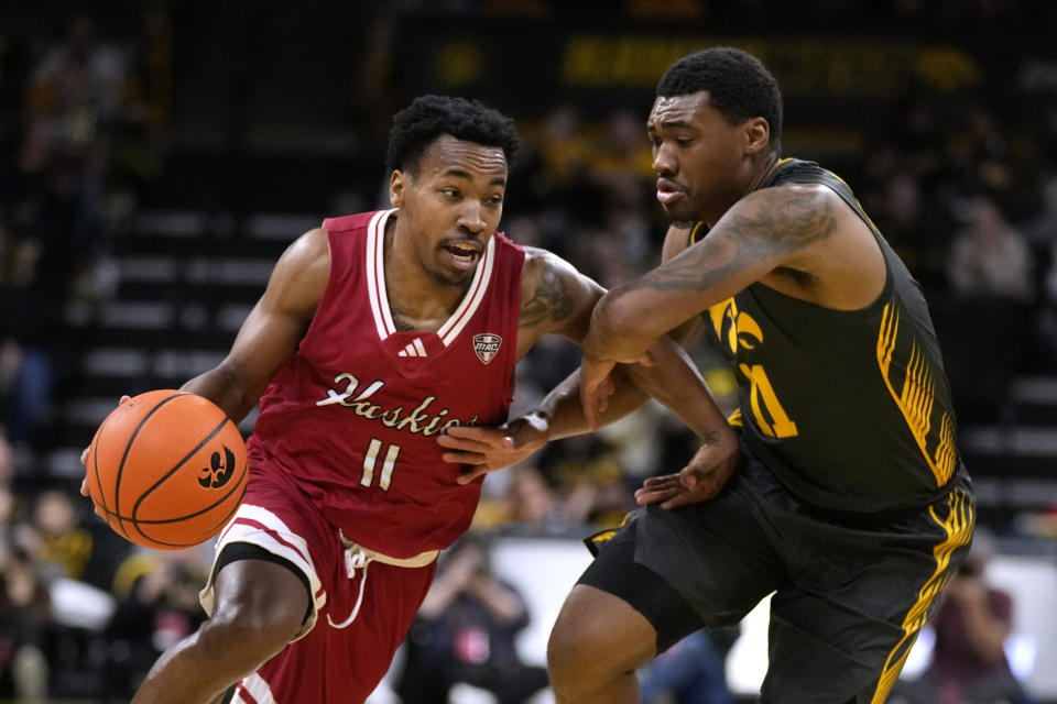Northern Illinois guard David Coit (11) drives past Iowa guard Tony Perkins (11) during the first half of an NCAA college basketball game, Friday, Dec. 29, 2023, in Iowa City, Iowa. (AP Photo/Charlie Neibergall)