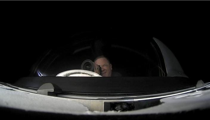 Inspiration4 crew member Chris Sembroksi looking through a telescope aboard as he orbits the Earth in a SpaceX Crew Dragon capsule.