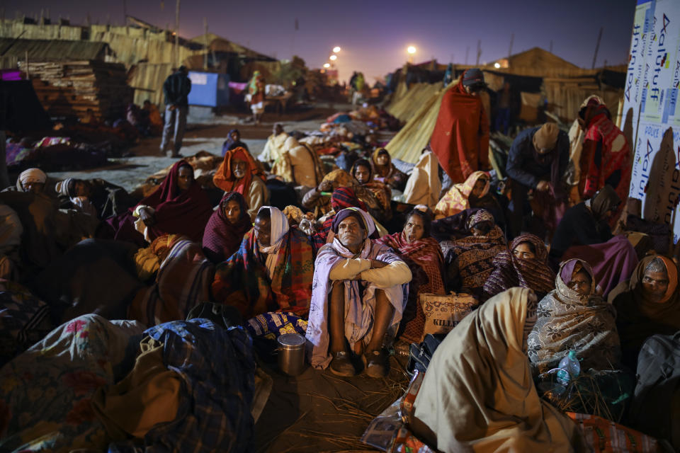 Hindu pilgrims spend the night huddled together after being forced by high tide to flee from their camps on the eve of Makar Sankranti festival on Sagar Island, an island in the Ganges delta, in the eastern Indian state of West Bengal, Tuesday, Jan. 14, 2020. Sagar and many other small islands which are part of the Sundarbans, the world's largest mangrove forest, have seen a dramatic rise in sea levels due to climate change. The highest point in the Sundarbans is around 3 meters (9.8 feet) and the mean elevation is less than a meter above sea level. (AP Photo/Altaf Qadri)