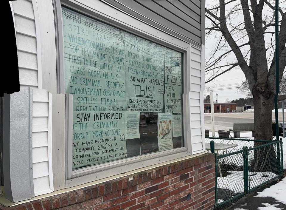 Messaging in the windows of Pizza by Paras refers to past legal disputes between the owners and the town over safety violations. Complaints about the building have brought the structure under the town's scrutiny once again.