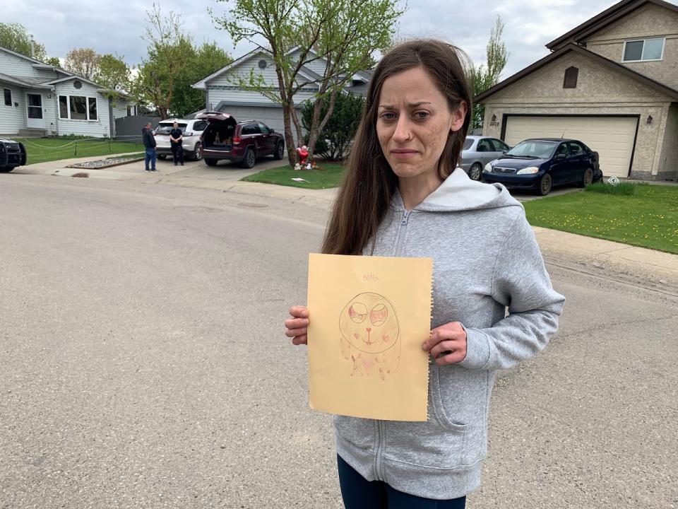 Melissa Desrosiers clutches a picture drawn by her daughter Bella Rose of the man suspected of stabbing the seven-year old. 