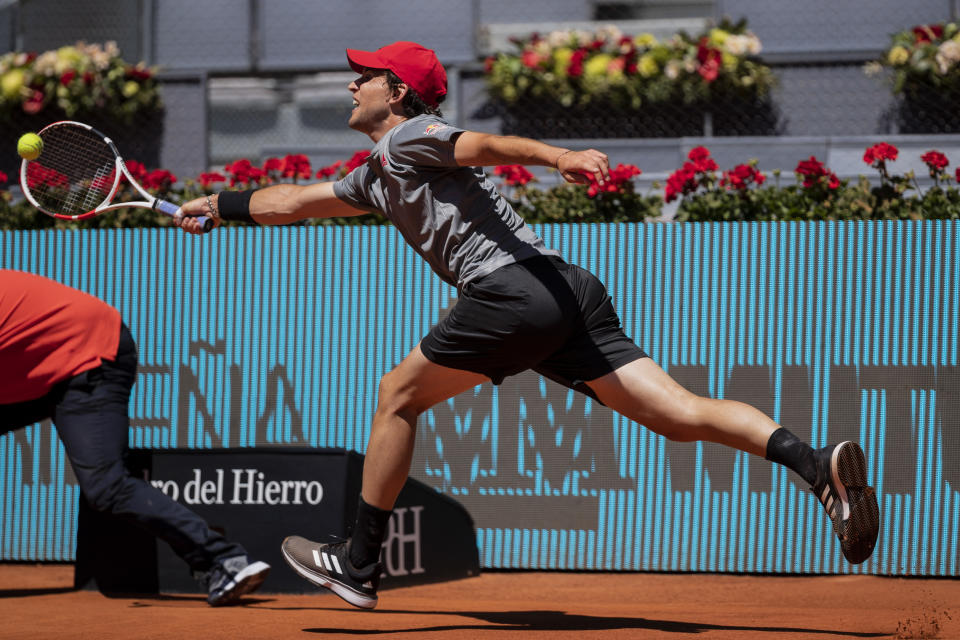 Austria's Dominic Thiem returns the ball to United States' John Isner during their match at the Mutua Madrid Open tennis tournament in Madrid, Spain, Friday, May 7, 2021. (AP Photo/Bernat Armangue)