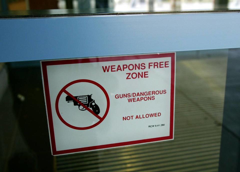 A sign on the main entrance of a Tri-Cities High School references the Revised Code of Washington that makes all school in the state of Washington off-limits to weapons.