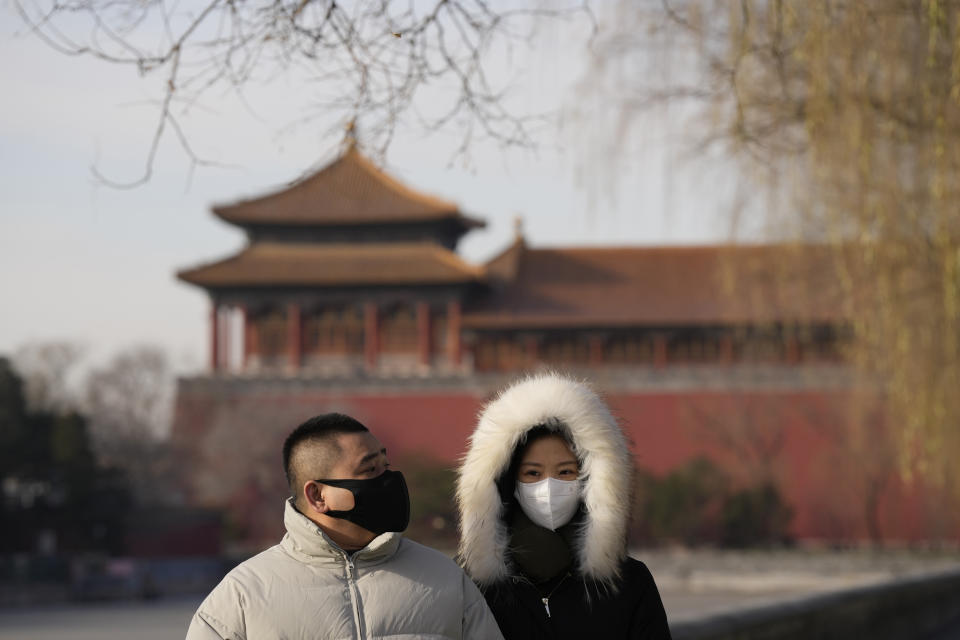 Residents wearing masks walk near the forbidden city in Beijing, Wednesday, Dec. 14, 2022. China's National Health Commission scaled down its daily COVID-19 report starting Wednesday in response to a sharp decline in PCR testing since the government eased antivirus measures after daily cases hit record highs. (AP Photo/Ng Han Guan)