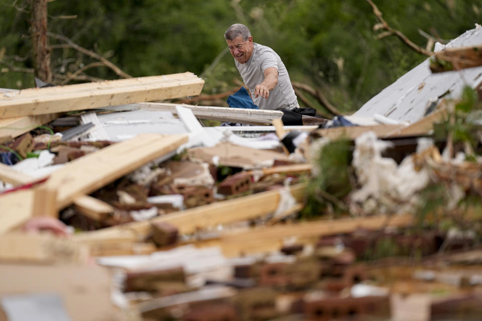 John Bernhardt picks up debris at his stormed damaged home Thursday, May 9, 2024, in Columbia, Tenn. A wave of dangerous storms began crashing over parts of the South on Thursday, a day after severe weather with damaging tornadoes killed several people in the region. (AP Photo/George Walker IV)