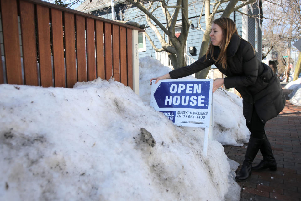 Lara Gordon places an open house sign on the Franklin Street home she is putting up for sale. Realtors think this could be a really busy spring season as buyers are trying to take advantage of the low interest rates. (Credit: Lane Turner/The Boston Globe via Getty Images)