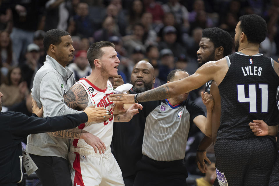 Houston Rockets guard Garrison Mathews (25) is restrained by Rockets coach Stephen Silas as Mathews yells at Sacramento Kings forward Chimezie Metu and forward Trey Lyles (41) during the second half of an NBA basketball game in Sacramento, Calif., Friday, Jan. 13, 2023. The Kings won 139-114. (AP Photo/José Luis Villegas)