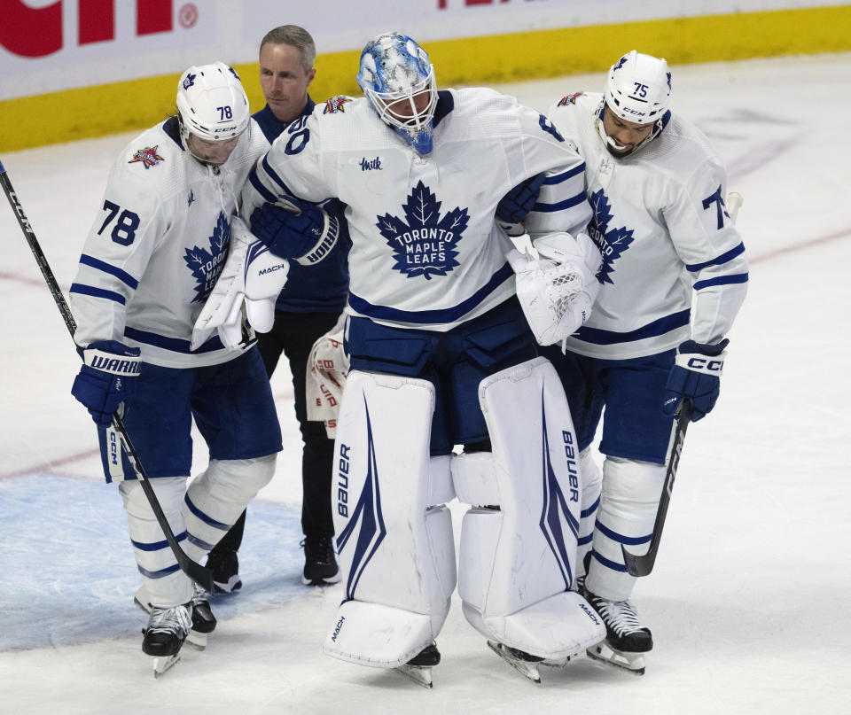 Toronto Maple Leafs defenseman TJ Brodie (78) and right wing Ryan Reaves (75) help goaltender Joseph Woll, center front, to the bench during third-period NHL hockey game action against the Ottawa Senators, Thursday, Dec. 7, 2023, in Ottawa. (Adrian Wyld/The Canadian Press via AP)