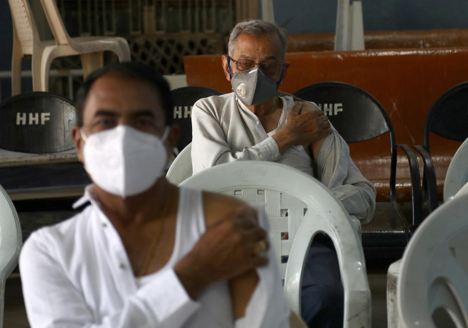 Indian men wait in an observation room after receiving the Covishield COVID-19 vaccine at a government hospital in Hyderabad, India, Friday, March 12, 2021. Pandemic-weary and sequestered mostly in their homes for a year, India's elderly are now standing in long lines at vaccination sites, then rolling up their sleeves to get shots protecting them against the coronavirus. (AP Photo/Mahesh Kumar A.)