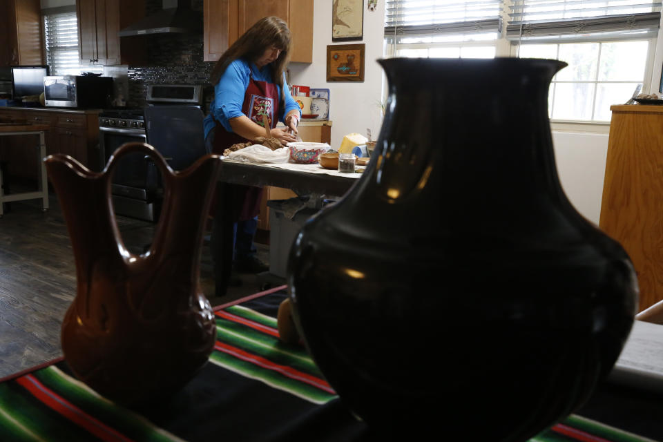 Artist Sharon Naranjo Garcia builds a pot with clay at her home in Ohkay Owingeh, formerly named San Juan Pueblo, in northern New Mexico, on Monday, Sept. 12, 2022. She is from the nearby Santa Clara Pueblo, where she learned to make the pueblo's distinctive pottery from older generations in her family. She and other artists say wildfires and flash floods, worsened by climate change, have made it more difficult to gather clay from the foothills of the pueblo’s canyon and wood used to fire the pottery. (AP Photo/Martha Irvine)