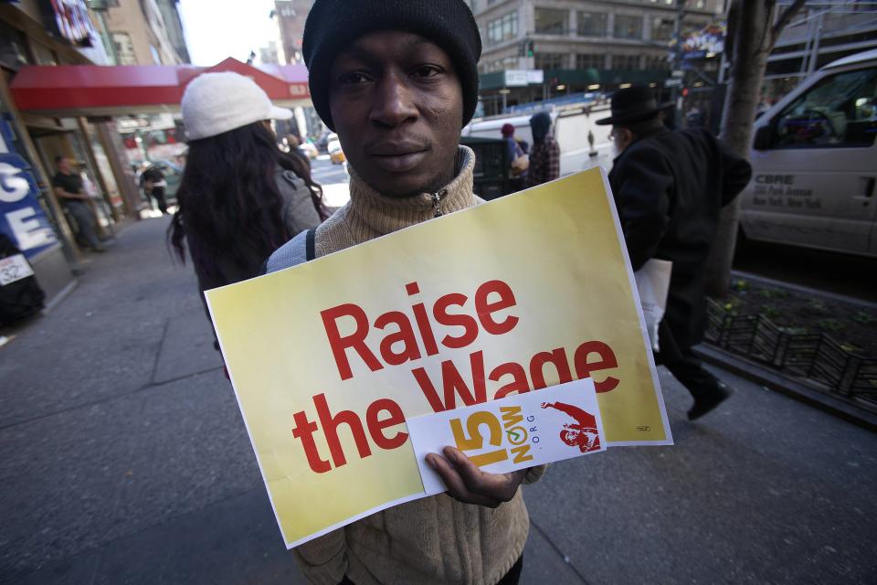 A protester holds a sign outside a McDonald's outlet, as they demand higher wages for fast food workers in the Manhattan borough of New York