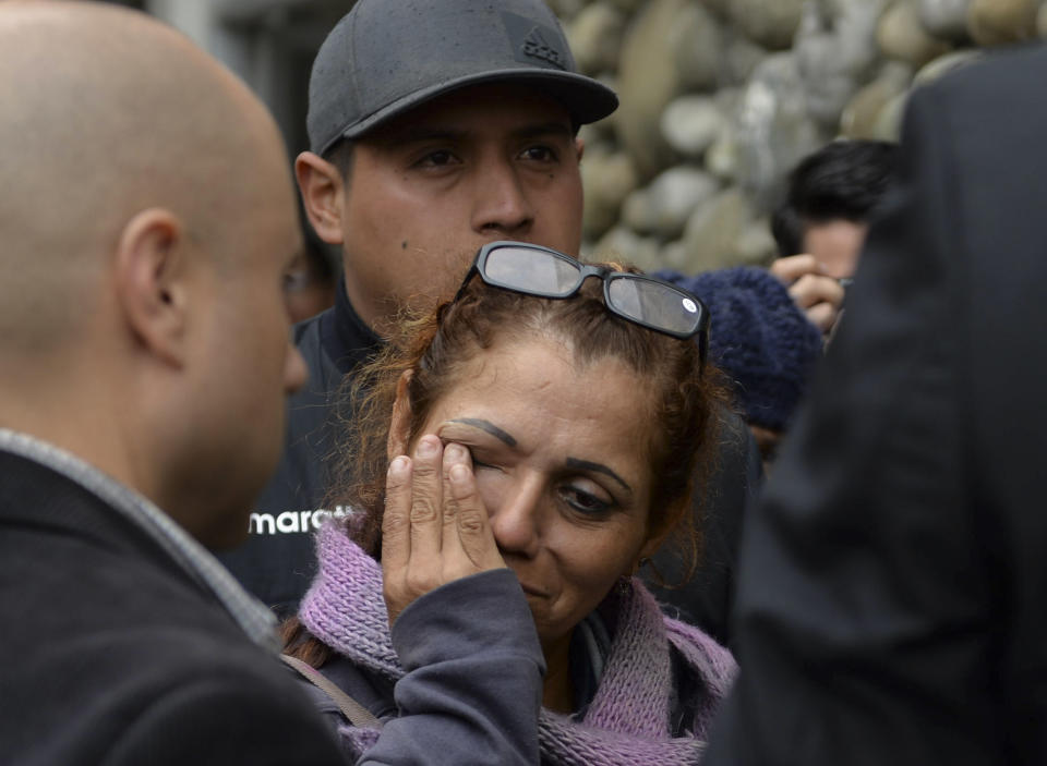 Una mujer llora mientras espera noticias afuera de la morgue a la que fueron trasladados hinchas de un equipo de futbol que fallecieron en un accidente de autobús en Cuenca, Ecuador, el lunes 13 de agosto de 2018. (AP Foto/Javier Ramirez)