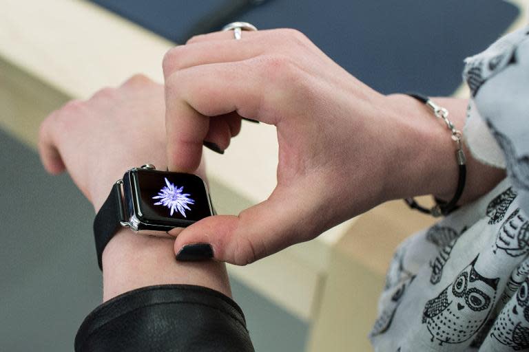 A customer tries on a model of the Apple Watch during the device presentation at the Apple Store in Lyon, France, on April 10, 2015