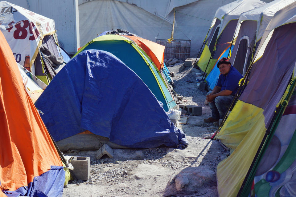 A migrant sits by his tent inside the Senda de Vida 2 shelter in Reynosa, Mexico, Thursday, Dec. 15, 2022. Nearly three thousand people cram inside the vast compound of tents over cement or gravel by the Rio Grande, steps from the border with the United States, and many more line up outside hoping to come in to relatively safety from the cartels that prey on migrants. (AP Photo/Giovanna Dell'Orto