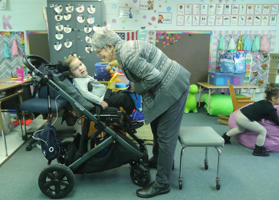 David Detwiler is greeted by his aide, Karen Parrish, as he arrives in his preschool classroom at Eastgate Early Childhood Development Center  in Louisville.