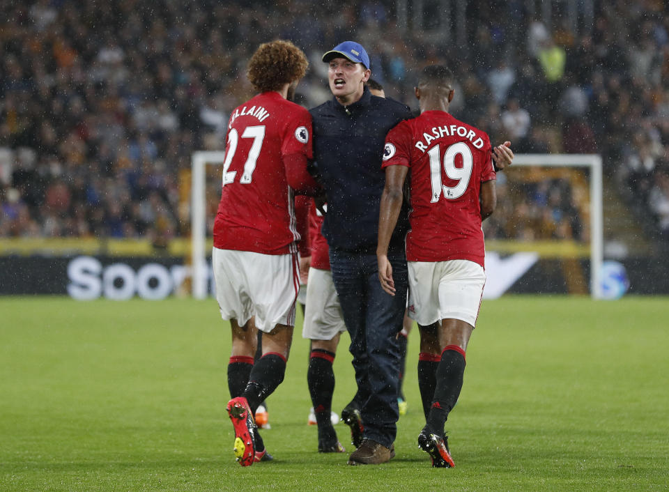 Football Soccer Britain- Hull City v Manchester United - Premier League - The Kingston Communications Stadium - 27/8/16 Manchester United's Marouane Fellaini and Marcus Rashford with a fan on the pitch after their first goal Action Images via Reuters / Lee Smith Livepic EDITORIAL USE ONLY. No use with unauthorized audio, video, data, fixture lists, club/league logos or "live" services. Online in-match use limited to 45 images, no video emulation. No use in betting, games or single club/league/player publications. Please contact your account representative for further details.