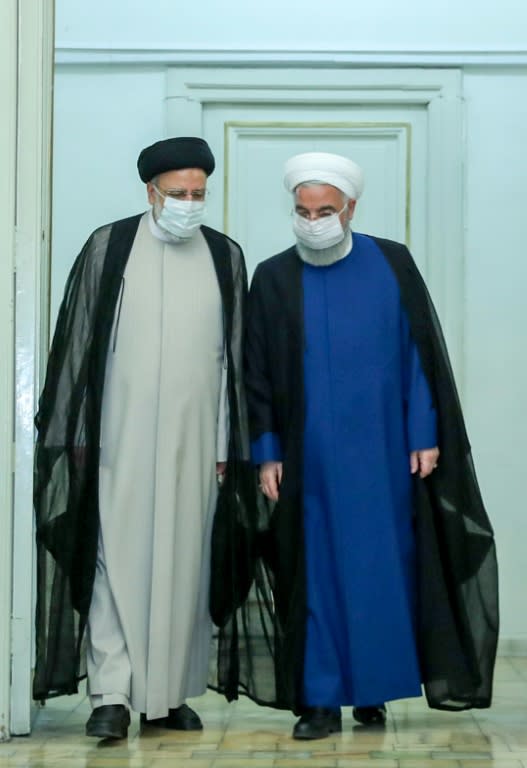 Raisi (L) is pictured meeting with outgoing President Hassan Rouhani in this picture provided by the presidential office on June 19, 2021