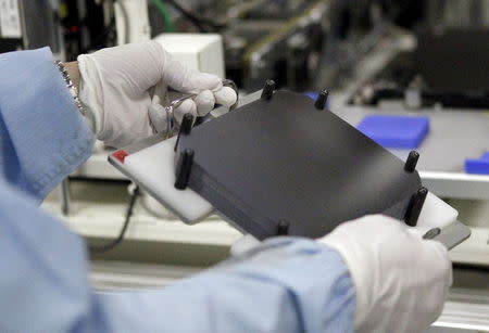 A worker works along the production line of the solar cell at Shap Corp's Sakai plant in Sakai, western Japan March 30, 2015. REUTERS/Reiji Murai