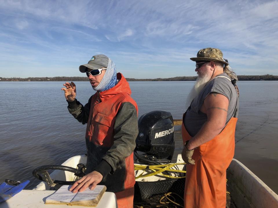 In this Saturday Dec. 29, 2018 photo, Matthew Balazik, a sturgeon research ecologist with Virginia Commonwealth University and the U.S. Army Corps of Engineers, and his brother, Martin Balazik, a volunteer with VCU's Rice Rivers Center, set out to catch baby Atlantic sturgeon on Virginia's James River. (AP Photo/Ben Finley)