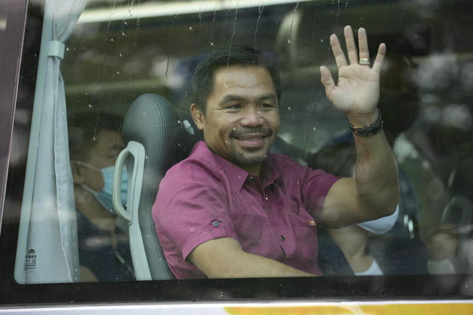 Retired Filipino boxing hero and senator Manny Pacquiao waves from his vehicle before filing his certificate of candidacy for next year's presidential elections at the Commission on Elections on Friday, Oct. 1, 2021 in Manila, Philippines. Friday marks the first day of a week-long period when politicians can file their certificates of candidacy for the May 9, 2022 national elections where Filipinos will get to vote for their next president, vice president, and other national and local officials.(AP Photo/Aaron Favila)