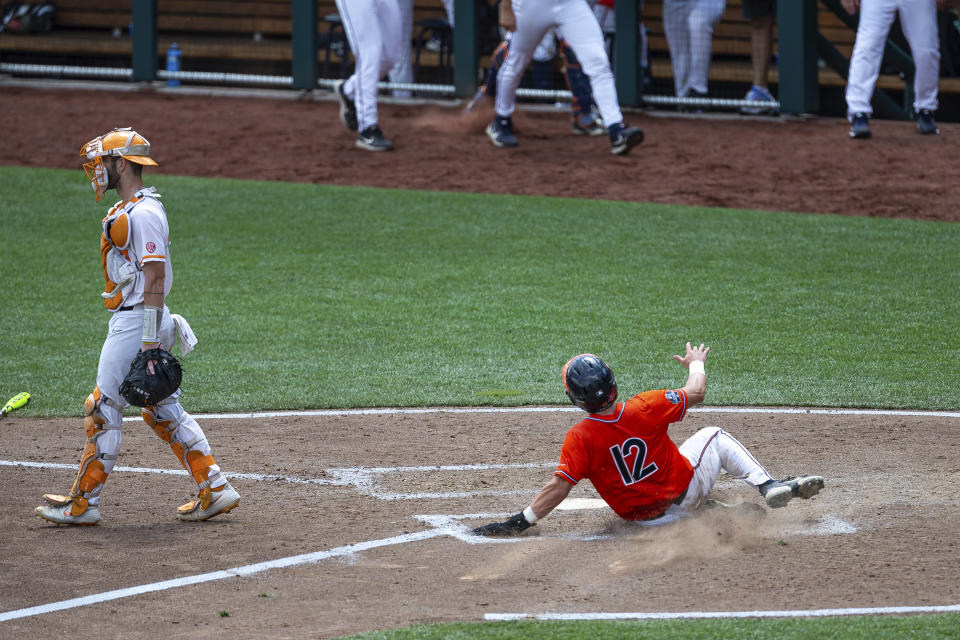 Virginia's Logan Michaels (12) slides home for a run against Tennessee in the seventh inning during a baseball game in the College World Series, Sunday, June 20, 2021, at TD Ameritrade Park in Omaha, Neb. (AP Photo/John Peterson)