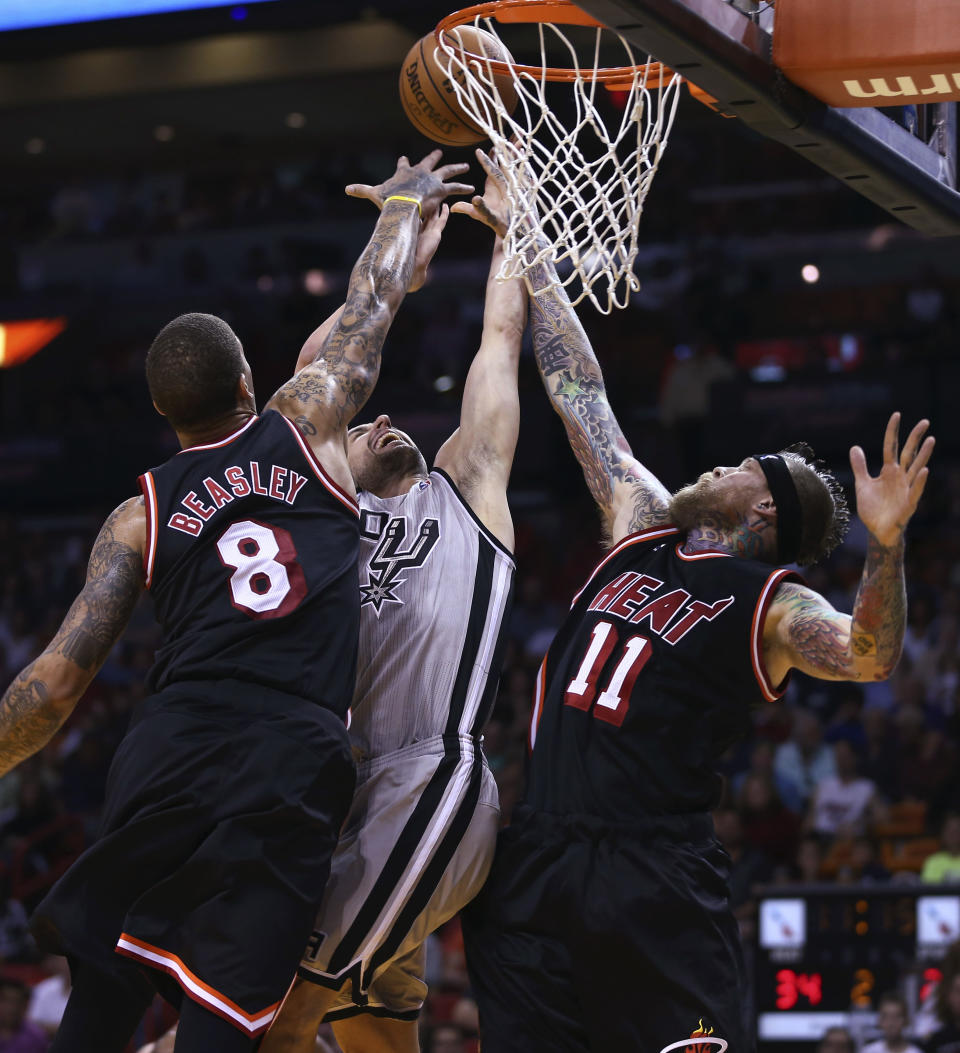 Miami Heat players Michael Beasley (8) and Chris Andersen (11) block San Antonio Spurs' Manu Ginbobil (20) during the first half of a NBA basketball game in Miami, Sunday, Jan. 26, 2014. (AP Photo/J Pat Carter)