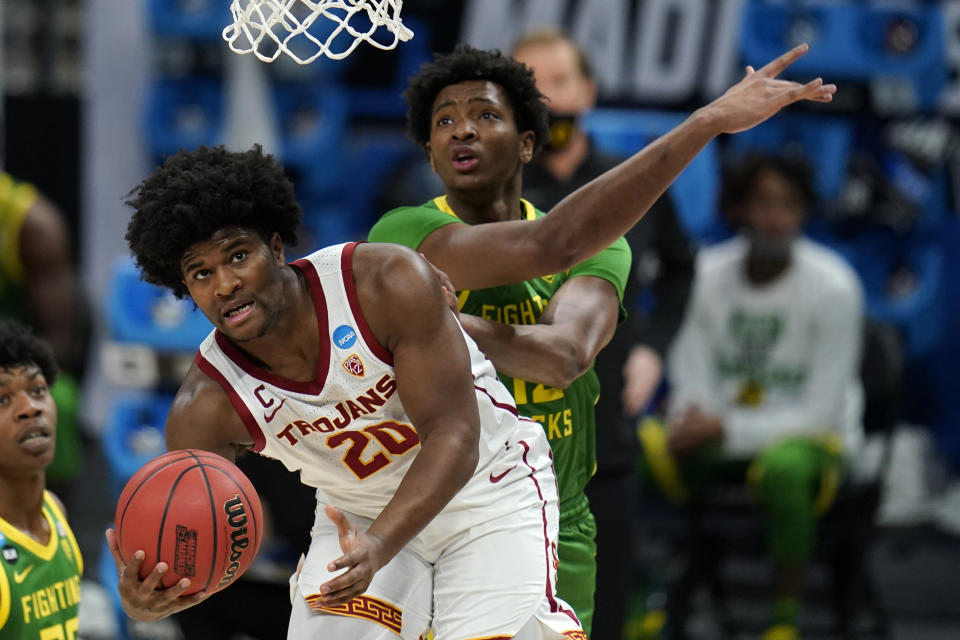 FILE- In this March 28, 2021, file photo, Southern California guard Ethan Anderson (20) shoots in front of Oregon forward Chandler Lawson, rear, during the first half of a Sweet 16 game in the NCAA college basketball tournament at Bankers Life Fieldhouse in Indianapolis. The Trojans were picked to finish third in the Pac-12. Ethan Anderson is back running the offense full-time after coming off the bench last season due to injury. (AP Photo/Jeff Roberson, File)