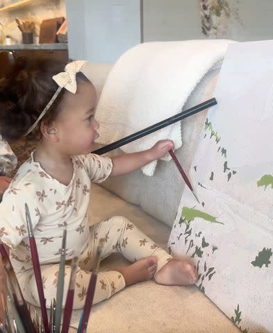 <p>Instagram/chrissyteigen</p> Chrissy Teigen's daughter Esti pretends to paint a picture