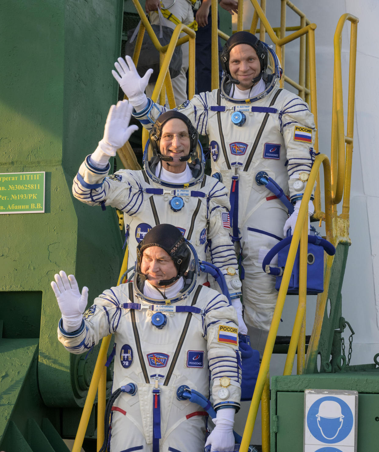 In this image provided by NASA, Expedition 72 crew members: Roscosmos cosmonaut Ivan Vagner, top, NASA astronaut Don Pettit, center, and Roscosmos cosmonaut Alexey Ovchinin, wave farewell prior to boarding the Soyuz MS-26 spacecraft for launch, Wednesday, Sept. 11, 2024 at the Baikonur Cosmodrome in Kazakhstan. Launch of the Soyuz rocket will send the trio on a mission to the International Space Station. (Bill Ingalls/NASA via AP)