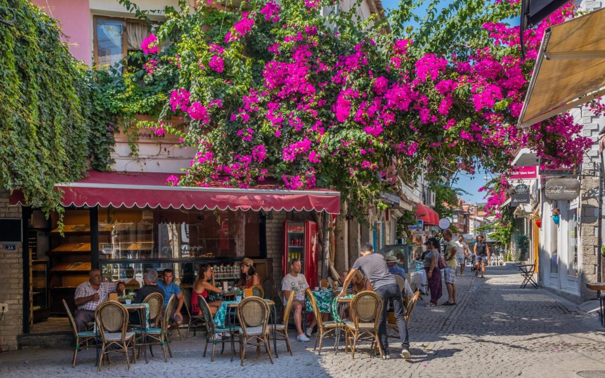 Alacati, Turkey: People eating in a cafe restaurant. The town is a popular tourist destination.