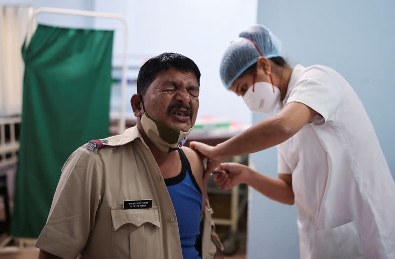 A policeman reacts as he receives a booster dose of the COVISHIELD vaccine manufactured by Serum Institute of India, at a vaccination centre, in Mumbai