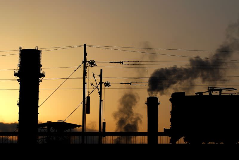 FILE PHOTO: A train passes near a powerplant's chimney in Skopje