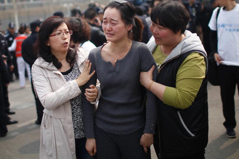 A relative (C) of passengers on missing Malaysia Airlines flight MH370 cries during a protest outside the Malaysian embassy in Beijing on March 25, 2014