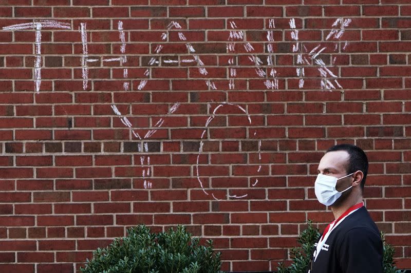 A hospital worker walks past a sign of thanks graffitied on the wall during the outbreak of Coronavirus disease (COVID-19), in the Manhattan borough of New York City