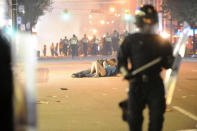 Riot police walk in the street as a couple kisses on June 15, 2011 in Vancouver, Canada. Vancouver broke out in riots after their hockey team the Vancouver Canucks lost in Game Seven of the Stanley Cup Finals. (Photo by Rich Lam/Getty Images)