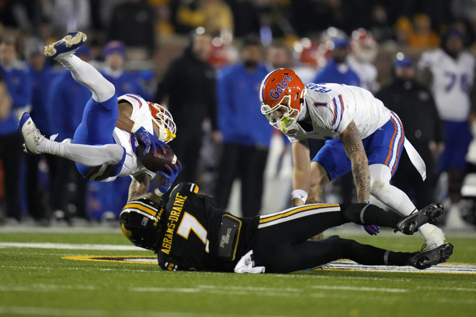 Missouri defensive back Kris Abrams-Draine (7) stops Florida wide receiver Eugene Wilson III, left, as Florida wide receiver Ricky Pearsall (1) watches during the first half of an NCAA college football game Saturday, Nov. 18, 2023, in Columbia, Mo. (AP Photo/Jeff Roberson)