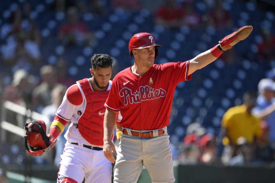 Philadelphia Phillies' J.T. Realmuto, right, gestures after he slid home to score against Washington Nationals catcher Keibert Ruiz, left, on a double by Andrew McCutchen during the sixth inning of a baseball game, Thursday, Sept. 2, 2021, in Washington. (AP Photo/Nick Wass)