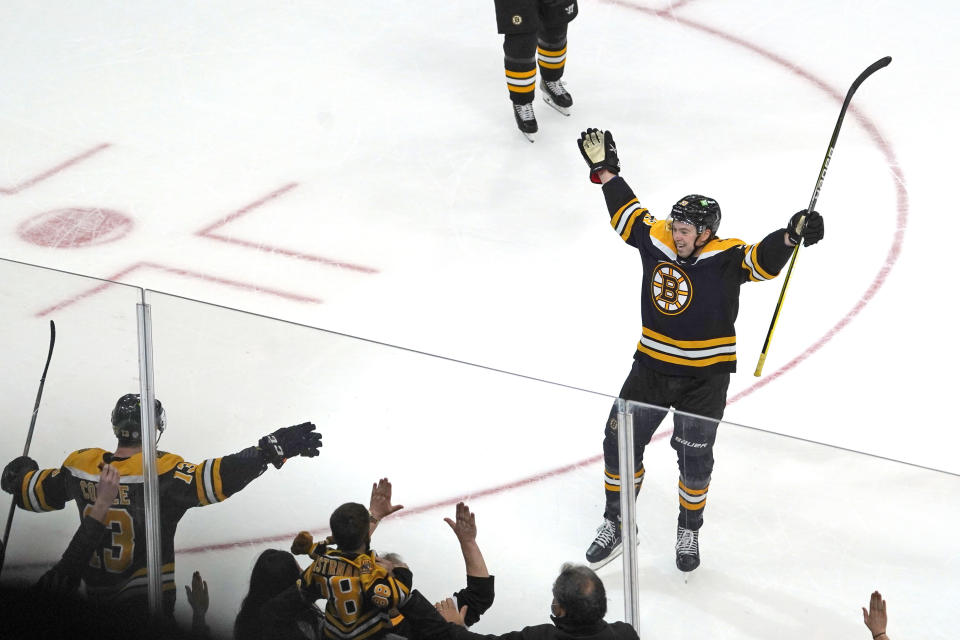 Boston Bruins defenseman Charlie McAvoy (73) celebrates with teammate Charlie Coyle after Coyle scored the game-winning goal during overtime in an NHL hockey game against the Buffalo Sabres, Saturday, Jan. 1, 2022, in Boston. (AP Photo/Mary Schwalm)