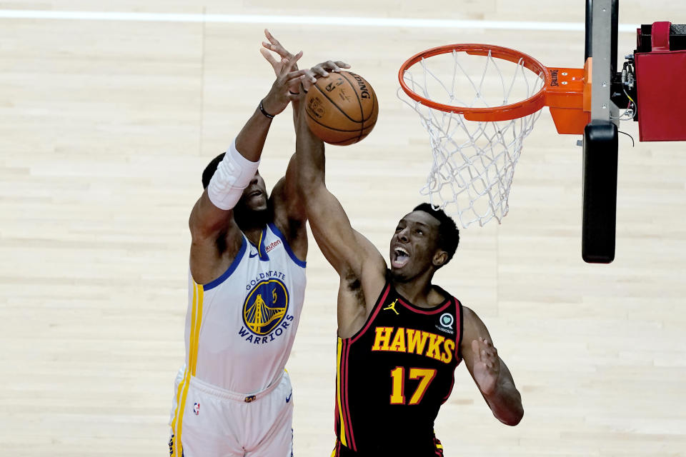 Golden State Warriors center Kevon Looney (5) and Atlanta Hawks forward Onyeka Okongwu (17) battle for a rebound in the first half of an NBA basketball game Sunday, April 4, 2021, in Atlanta. (AP Photo/John Bazemore)