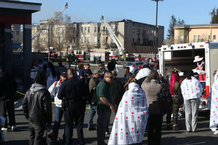 Firefighters battle a 4 alarm blaze in a three-story apartment building in Oakland, California, U.S. March 27, 2017. REUTERS/Beck Diefenbach