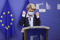 FILE - In this Nov. 16, 2020, file photo, European Commission President Ursula von der Leyen removes her face mask as she arrives to give a statement at the EU headquarters in Brussels. The European Union still hasn't completely sorted out its messy post-divorce relationship with Britain — but it has already been plunged into another major crisis. This time the 27-member union is being tested as Poland and Hungary block passage of its budget for the next seven years and an ambitious package aimed at rescuing economies ravaged by the coronavirus pandemic. (Kenzo Tribouillard, Pool Photo via AP, File)