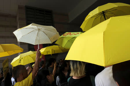 Pro-democracy supporters hold yellow umbrellas to support leaders of Occupy Central activists, outside the court in Hong Kong, China April 24, 2019. REUTERS/Tyrone Siu